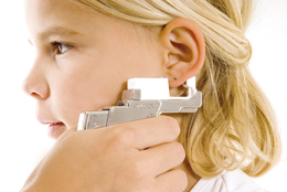 Gently piercing the ear; the clasp is positioned at the same time