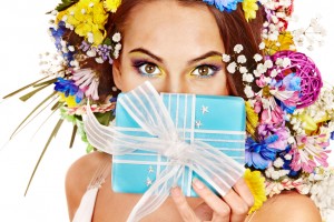 Woman with gift box and flower bouquet .